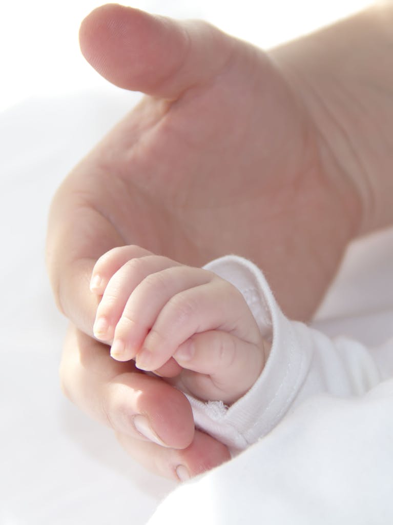 Cute baby hand is holding father's finger